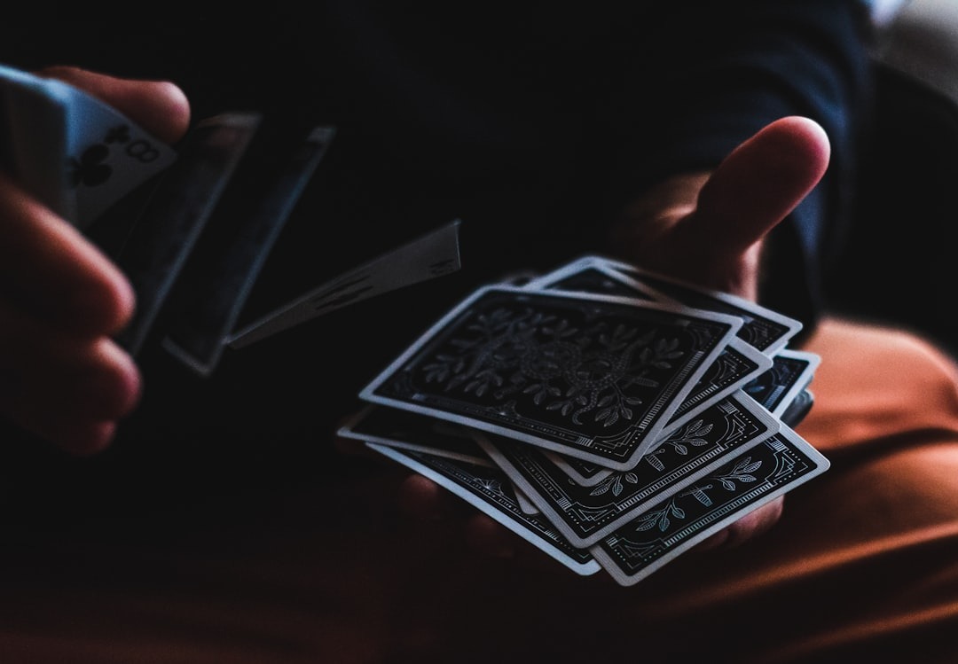 Hands skillfully shuffling a deck of black playing cards.